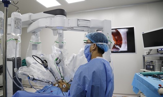 Các bác sĩ điều khiển robot phẫu thuật nội soi cho bệnh nhân ung thư tại bệnh viện K. Ảnh: T.H