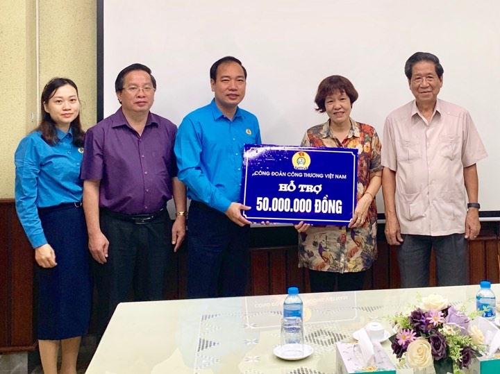 Đồng chí Trần Quang Huy, Ủy viên Đoàn Chủ tịch Tổng Liên đoàn Lao động Việt Nam, Chủ tịch Công đoàn Công thương Việt Nam (thứ 3 từ trái qua) trao tiền hỗ trợ tới đại diện Công ty.