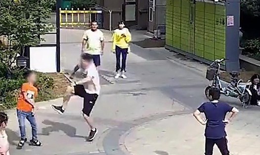 Bé trai Trung Quốc bị đạp bay người sau khi vô tình đá bóng trúng bạn gái của nam thanh niên. Ảnh: SCMP.