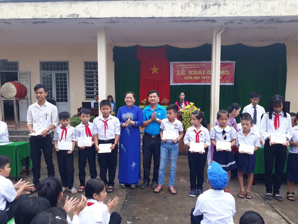 Chủ tịch LĐLĐ tỉnh Hậu Giang Lê Thị Thanh Lam và Chủ tịch LĐLĐ huyện Long Mỹ Ngô Hồng Luận trao học bổng cho học sinh tại Trường Tiểu học Vĩnh Viễn 1, huyện Long Mỹ. Ảnh: H.P