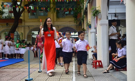 Các giáo viên trường tiểu học Phan Thanh (thành phố Đà Nẵng) dẫn các em học sinh lớp 1 vào làm lễ khai giảng năm học mới. ảnh: H.Vinh