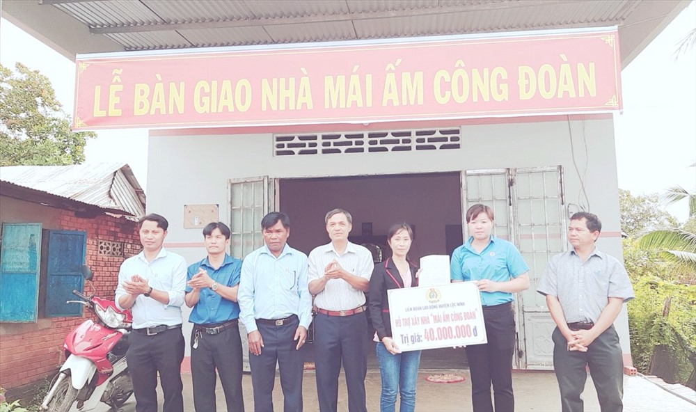 Bà Đinh Thị Mỹ Hạnh-Chủ tịch LĐLĐ huyện Lộc Ninh trao bảng tượng trưng tặng tiền hỗ trợ xây nhà cho chị Hằng.