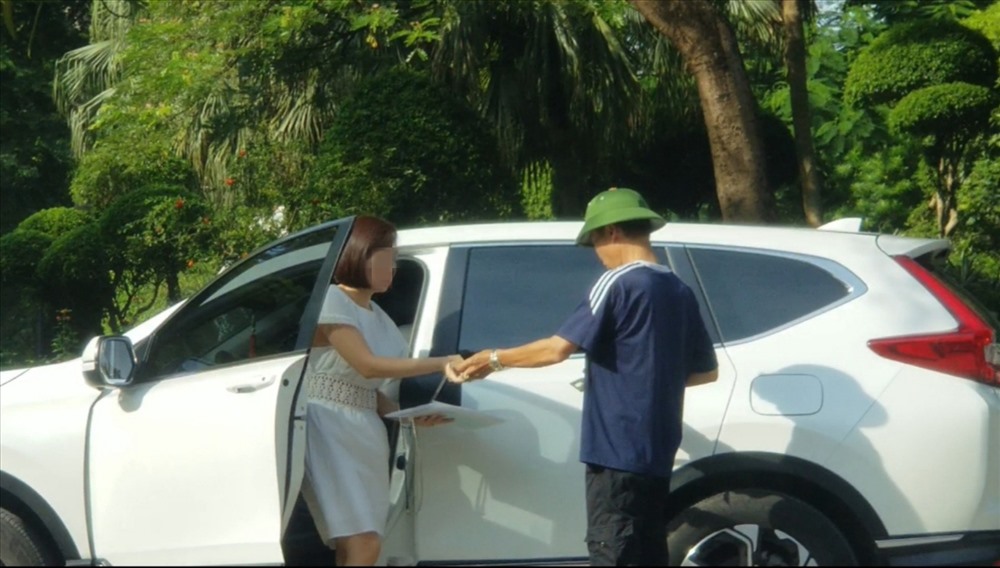 Đối tượng bãi giữ xe trái phép ở vườn hoa Kim Đồng thu tiền gửi xe của khách. Ảnh: CÔNG BẰNG