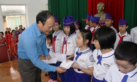 Đồng chí Nguyễn Tử Phương - Chủ tịch LĐLĐ tỉnh Nghệ An tặng quà cho học sinh huyện Quỳnh Lưu. Ảnh: TT