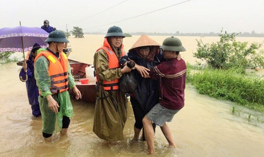 Cán bộ xã Lộc Yên đưa sản phụ Dung đi sinh nở giữa mưa lũ. Ảnh: LY