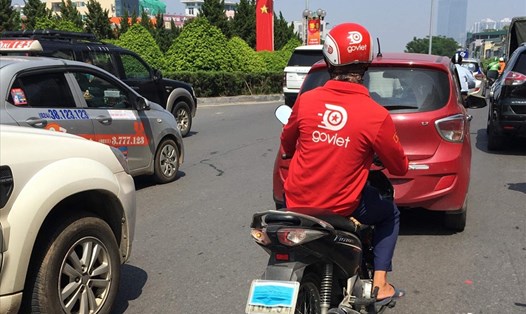 Một lái xe ôm công nghệ dùng khẩu trang che biển số trên đường Xã Đàn, Hà Nội. Ảnh: Q.H