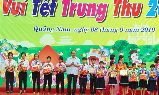 Thủ tướng Chính phủ Nguyễn Xuân Phúc trao tặng quà cho các em có hoàn cảnh khó khăn, học giỏi. Ảnh: T.C