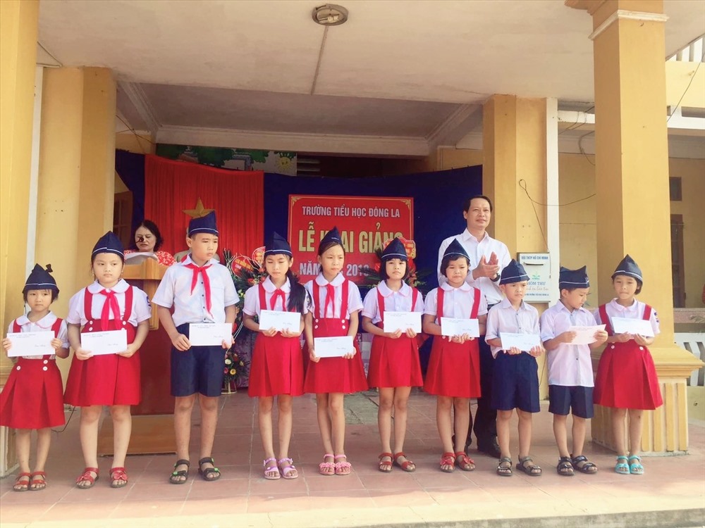 Đồng chí Hoàng Thái Phúc – Bí thư huyện ủy trao quà cho các em học sinh. Ảnh: B.Mạnh