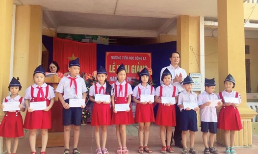 Đồng chí Hoàng Thái Phúc – Bí thư huyện ủy trao quà cho các em học sinh. Ảnh: B.Mạnh