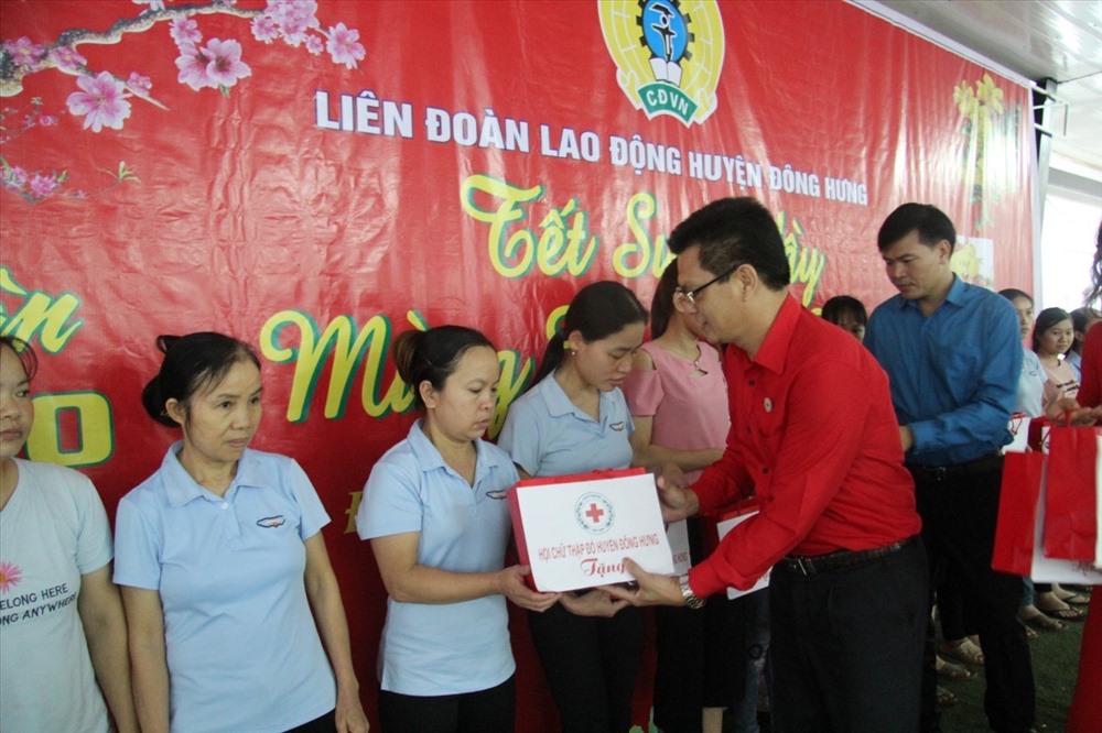 Lãnh đạo Liên đoàn Lao động huyện Đông Hưng và Hội Chữ thập đỏ huyện trao quà cho công nhân lao động.