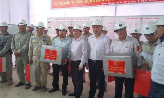 Bộ trưởng Nguyễn Văn Thể (thứ 5 từ trái sang) trao quà Tết cho CNLĐ tại công trình. Ảnh: K.Q