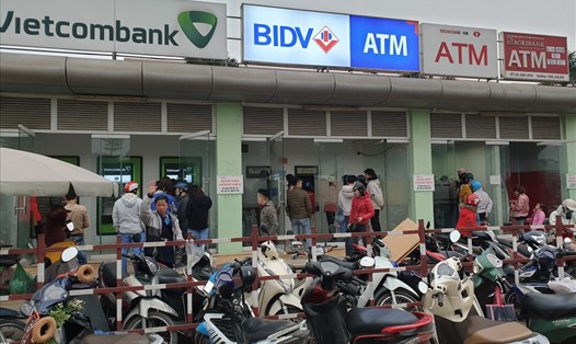 Công nhân xếp hàng rút tiền tại cây ATM ở Khu công nghiệp Bắc Thăng Long (Đông Anh, Hà Nội). Ảnh: Tùng Giang