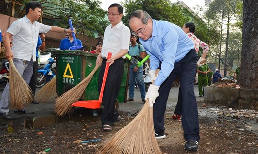 Bí thư Thành ủy TPHCM Nguyễn Thiện Nhân tham gia dọn rác trên đường Đào Duy Từ (quận 10, TPHCM). Ảnh: VIỆT DŨNG