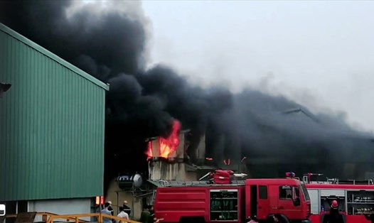Lửa bốc cháy dữ dội tại khu vực kho chứa hàng của cơ sở sản xuất bao bì Trường Thịnh. Ảnh: NT