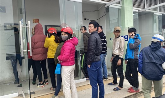 Công nhân và người dân sống quanh khu công nghiệp Bắc Thăng Long xếp hàng chờ rút tiền từ cây ATM. Ảnh L.Hương