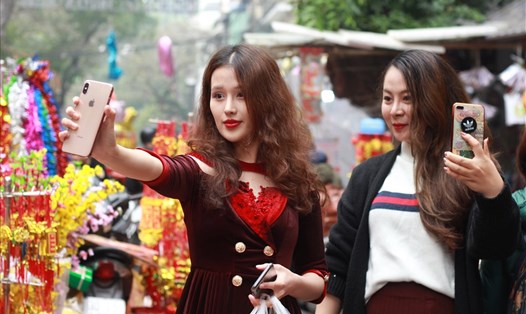 Nhiều cô gái vừa đi sắm Tết, vừa tranh thủ "check-in" tại chợ hoa Hàng Lược.