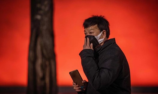 Một người đàn ông đeo mặt nạ gần Thiên An Môn, Bắc Kinh. Ảnh: AFP
