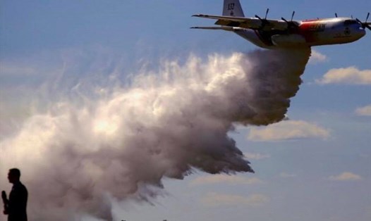Chiếc máy bay không vận C-130 Hercules đang thả 15.000 lít lỏng chống cháy để dập lửa các đám cháy rừng. Ảnh: Reuters