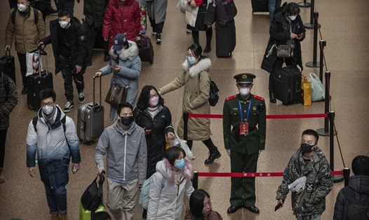 Du khách tại một nhà ga đường sắt ở Bắc Kinh đều đeo mặt nạ bảo vệ. Ảnh: Kevin Frayer / Getty Images.