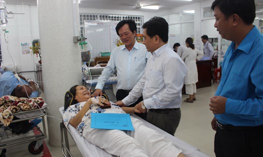 Bác sĩ Tạ Văn Trầm (bên trái) và Phó Chủ tịch UBND tỉnh Tiền Giang - ông Trần Văn Dũng thăm nạn nhân cấp cứu trong đêm giao thừa tại bệnh viện Đa khoa Tiền Giang. Ảnh: K.Q