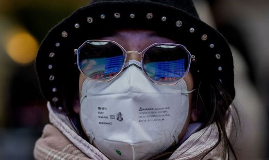 Một phụ nữ đeo khẩu trang khi di chuyển dịp Tết Nguyên đán ở Bắc Kinh vì lo ngại virus gây viêm phổi lạ ở Trung Quốc. Ảnh: AFP.