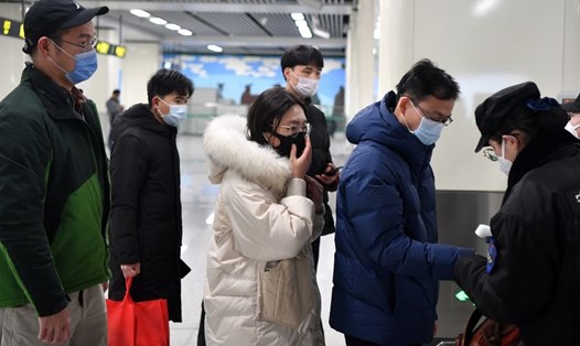 Hành khách xếp hàng đo thân nhiệt tại nhà ga ở Trịnh Châu, tỉnh Hà Nam ngày 26.1. Ảnh: Xinhua