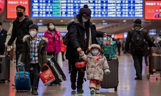 Du khách đeo khẩu trang tại nhà ga ở Bắc Kinh khi di chuyển trong đợt cao điểm dịch virus corona. Ảnh: AFP/Getty.