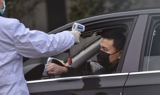 Cảnh sát kiểm tra nhiệt độ tài xế trên đường phố ở ngoại ô Vũ Hán, Trung Quốc. Ảnh: AFP