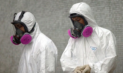 Nhân viên y tế mặc quần áo bảo hộ đầy đủ trong các hoạt động dọn dẹp tại Amoy Gardens, nơi có hơn 200 cư dân bị nhiễm virut SARS (Hội chứng hô hấp cấp tính nặng), ngày 4 tháng 4 năm 2003 tại Hồng Kông. Ảnh: Christian Keenan / Getty.