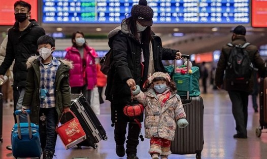 Du khách đeo khẩu trang tại nhà ga ở Bắc Kinh khi di chuyển trong đợt cao điểm dịch virus corona. Ảnh: AFP/Getty.