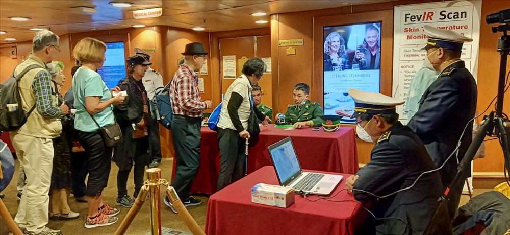 Sử dụng máy tầm soát thân nhiệt nhằm phát hiện các dấu hiệu bất thường trong phòng chống dịch do virus Corona trong quá trình làm thủ tục cho khách ở Cảng Chân Mây đầu năm mới. Ảnh: Lê Tiến.