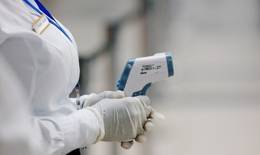 Nhân viên y tế cầm nhiệt kế đo thân nhiệt để sàng lọc hành khách nhiễm virus Corona tại sân bay quốc tế Kotoka, Ghana. Ảnh: Reuters