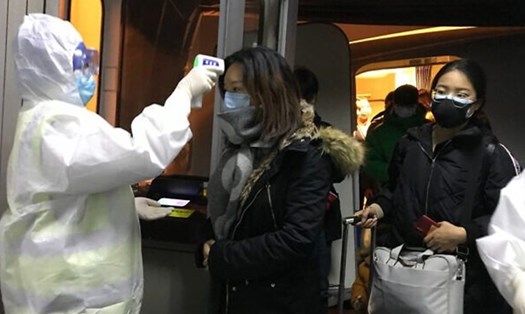 Hành khách được kiểm tra thân nhiệt tại sân bay ở Bắc Kinh. Ảnh: AP.