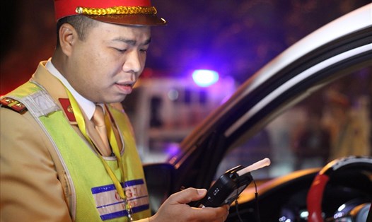 Cảnh sát giao thông kiểm tra nồng độ cồn tài xế lái xe. Ảnh T.Vương