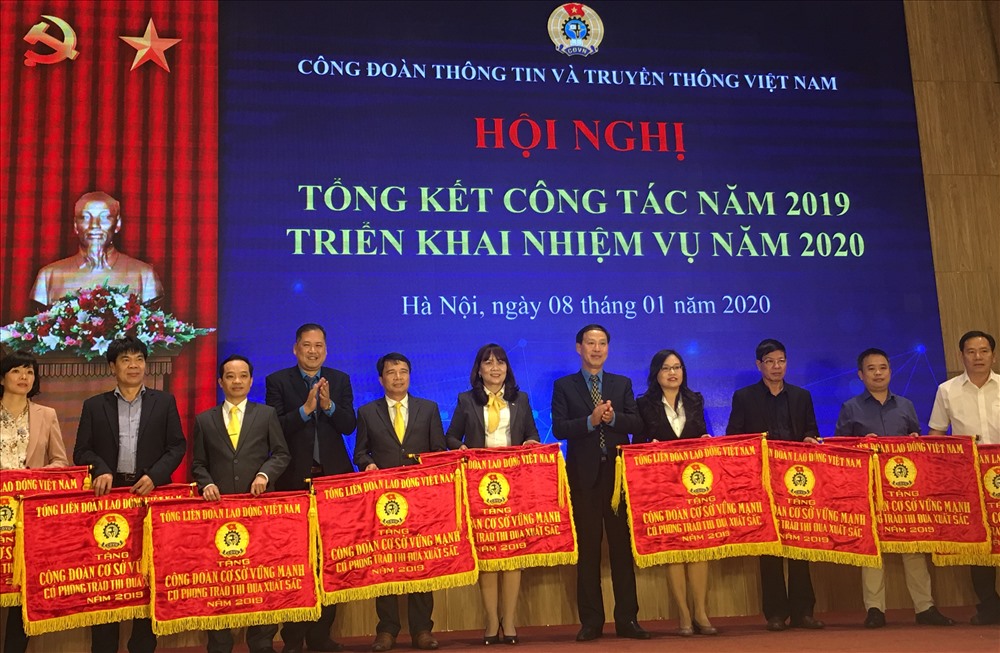 Các đồng chí Nguyễn Minh Dũng - Uỷ viên Đoàn Chủ tịch, Trưởng ban Tài chính Tổng Liên đoàn và Chu Văn Bình - Chủ tịch Công Công đoàn Thông tin và Truyền thông Việt Nam trao tặng Cờ thi đua của Tổng Liên đoàn cho các tập thể. Ảnh: T.E.A