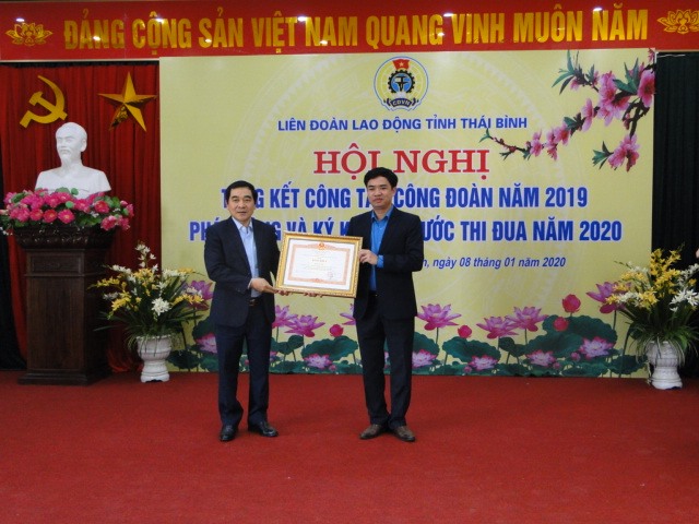 Đồng chí Nguyễn Tiến Thành - Phó bí thư Tỉnh ủy trao bằng khen của Thủ tướng Chính phủ cho đồng chí Bùi Xuân Vinh - Chủ tịch Liên đoàn Lao động tỉnh.