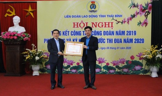 Đồng chí Nguyễn Tiến Thành - Phó bí thư Tỉnh ủy trao bằng khen của Thủ tướng Chính phủ cho đồng chí Bùi Xuân Vinh - Chủ tịch Liên đoàn Lao động tỉnh.