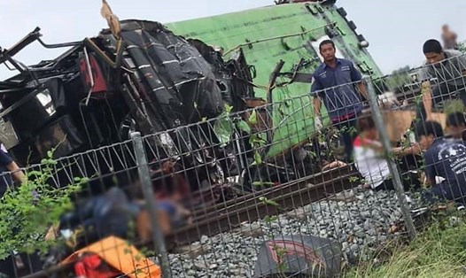 Chiếc xe buýt nằm trên đường ray xe lửa sau khi xảy ra vụ tai nạn ở gần Bangkok, Thái Lan. Ảnh: AP