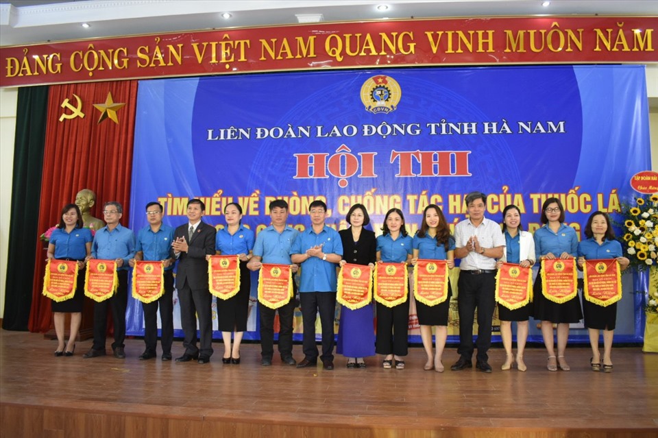 Ông Vũ Mạnh Tiêm - Phó trưởng ban Tuyên giáo Tổng Liên đoàn, ông Phạm Ngọc Long - Phó trưởng ban Dân vận tỉnh ủy, ông Trịnh Văn Bừng - Ủy viên BCH Tổng LĐLĐ Việt Nam, Tỉnh ủy viên, Chủ tịch LĐLĐ tỉnh trao cờ lưu niệm cho 11 đội thi. Ảnh: Phúc Lộc