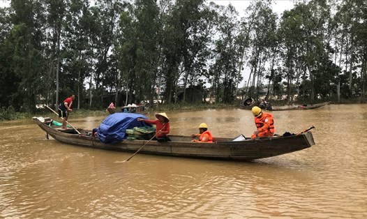 Người dân phường Đông Lễ, Thành phố Đông Hà (tỉnh Quảng Trị) chủ động đưa thuyền “rước” công nhân điện lực đi kiểm tra lưới điện trong lũ. Ảnh: L.M.T