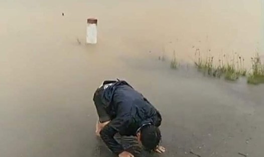 Người chồng ngã quỵ bên biển nước mênh mông  - cảnh tượng thương tâm xảy ra ở huyện Phong Điền - Thừa Thiên-Huế trong cơn bão lũ vừa qua. Ảnh: Cắt từ clip.