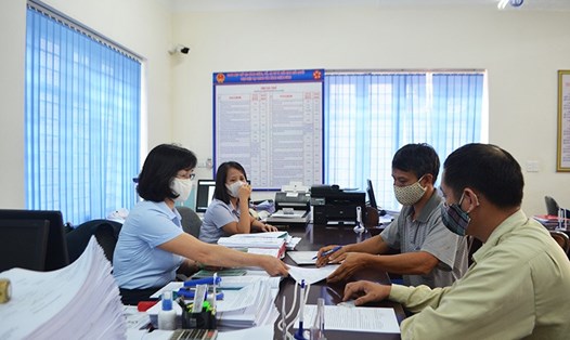 Cán bộ BHXH tỉnh Quảng Ninh tiếp nhận hồ sơ và trả kết quả giải quyết các thủ tục hành chính về BHXH tại Trung tâm Hành chính công TP.Uông Bí. Ảnh: BHXHQN