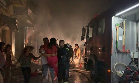 Lực lượng chức năng và người dân đã cứu 5 người kẹt trong cửa hàng kinh doanh gas bị cháy. Ảnh: Đ. Lê