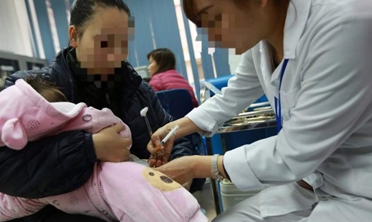 Cán bộ y tế tiêm vắc xin cho trẻ. Ảnh: Hải Nguyễn