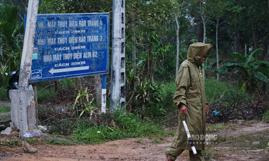 Lực lượng chức năng đội mưa thực hiện nhiệm vụ tại lối ra - vào khu thủy điện Rào Trăng 3. Ảnh: Tùng Giang.