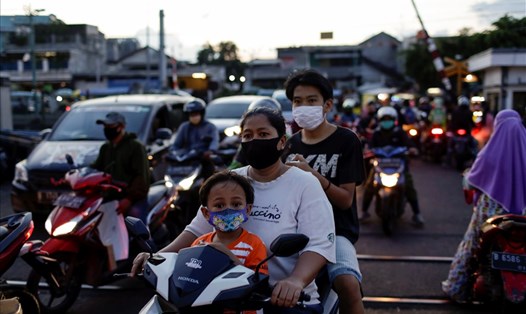 Người dân đeo khẩu trang trong lúc chờ đi qua đường sắt ở Indonesia - quốc gia hiện có số ca COVID-19 cao nhất Đông Nam Á. Ảnh: Reuters.