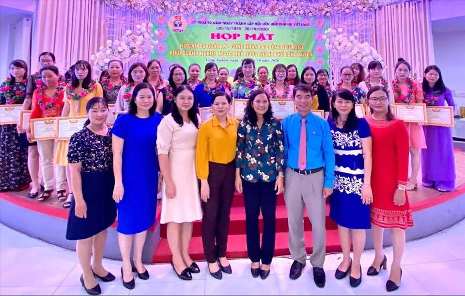 Phó Chủ tịch LĐLĐ tỉnh An Giang Phan Thị Diễm cùng lãnh đạo thành phố, lãnh đạo LĐLĐ TP Long Xuyên chụp ảnh lưu niệm với 30 cán bộ quản lý và nữ CNLĐ tiêu biểu được tuyên dương. Ảnh: Cẩm Tú