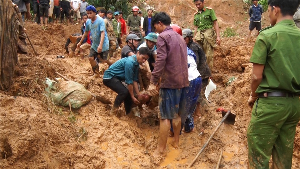 Người dân và cơ quan chức năng đưa thi thể người chết do sạt lở đất ra ngoài. Ảnh: Công Sang