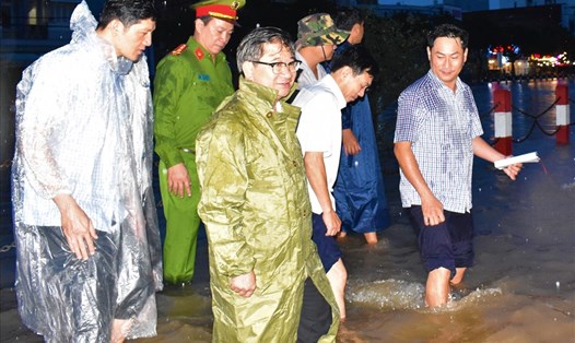 Chủ tịch UBND TP.Cần Thơ Trần Việt Trường (đeo kính, áo mưa xanh) cùng đoàn công tác kiểm tra tình hình ngập lụt tại đường Huỳnh Cương gần hồ Xáng Thổi vào chiều tối ngày 18.10.2020. Ảnh: Thành Nhân