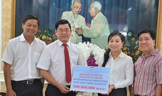 Ông Lê Văn Minh (bìa trái) và ông Bùi Hải Thành (thứ hai từ trái qua) trao tiền CNVCLĐ của EVNHCMC  ủng hộ đồng bào bị lũ lụt ở miền Trung. Ảnh: Nam Dương